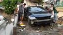 Warga melihat kondisi mobil yang mengalami kecelakaan tunggal di kawasan Pasar Minggu, Jakarta Selatan, Sabtu (8/6/2019). Mobil yang nyaris tercebur sungai itu dikendarai seorang pemuda yang nekat melakukan aksi kebut-kebutan saat jalanan ibu kota lengang. (Liputan6.com/Herman Zakharia)