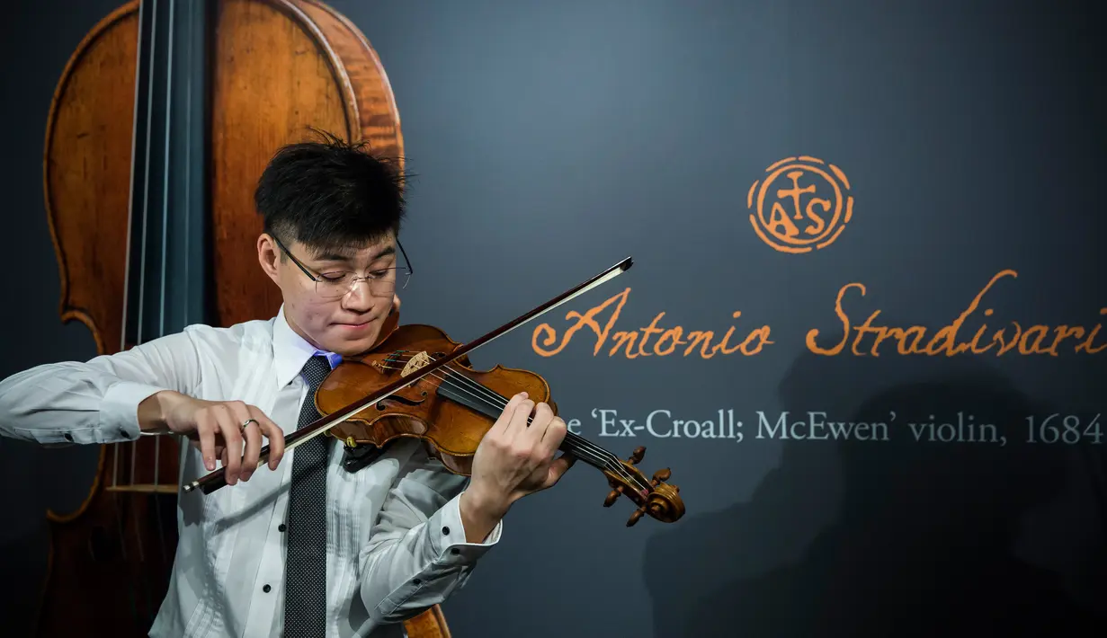 Pemain biola memainkan biola langka 1684 buatan Antonio Stradivari saat diperkenalkan di hadapan pers di Hong Kong (21/2). (AFP Photo / Isaac Lawrence)