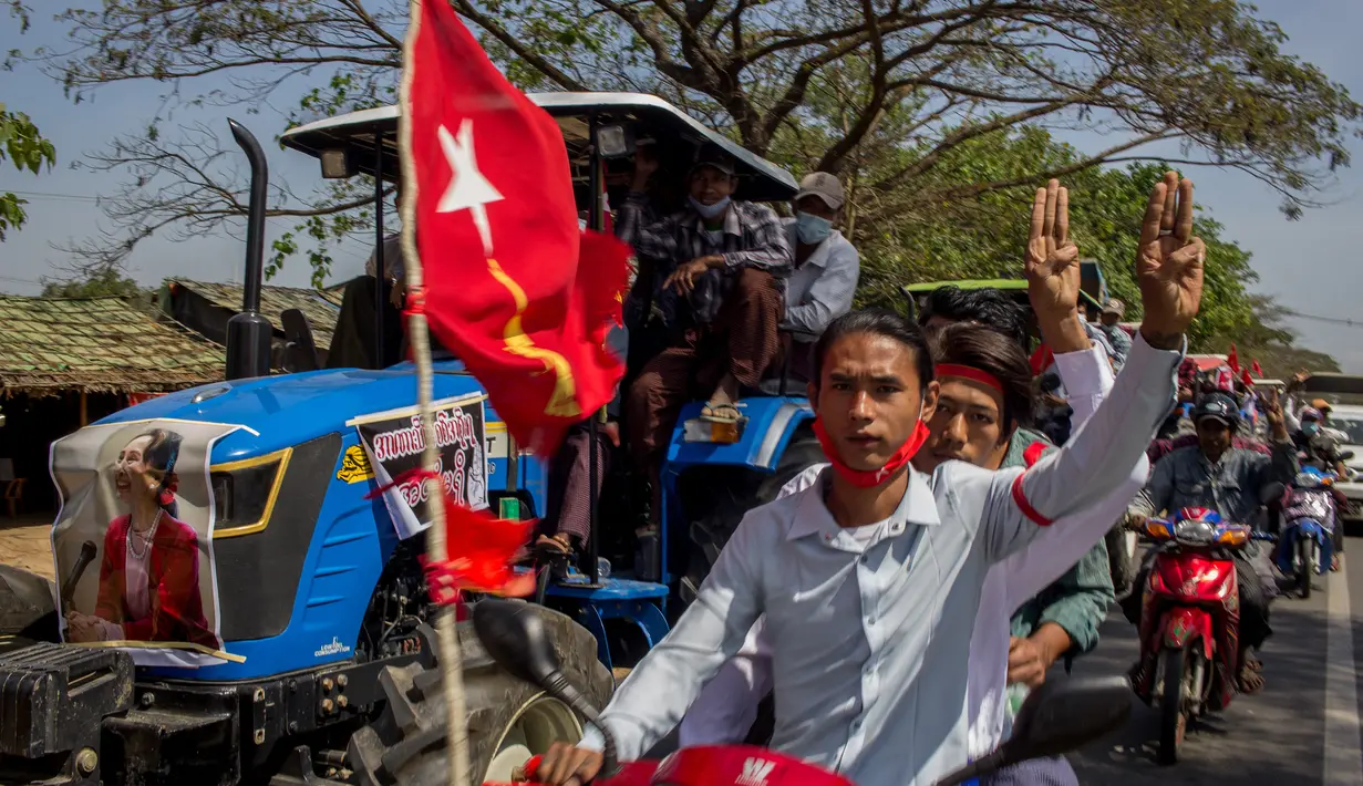 Para pengunjuk rasa dengan skuter dan petani yang mengendarai traktor dengan poster pemimpin sipil Myanmar Aung San Suu Kyi yang ditahan di bagian depan mengambil bagian dalam demonstrasi menentang kudeta militer di Thongwa, di pinggiran Yangon (12/2/2021). (AFP/STR)