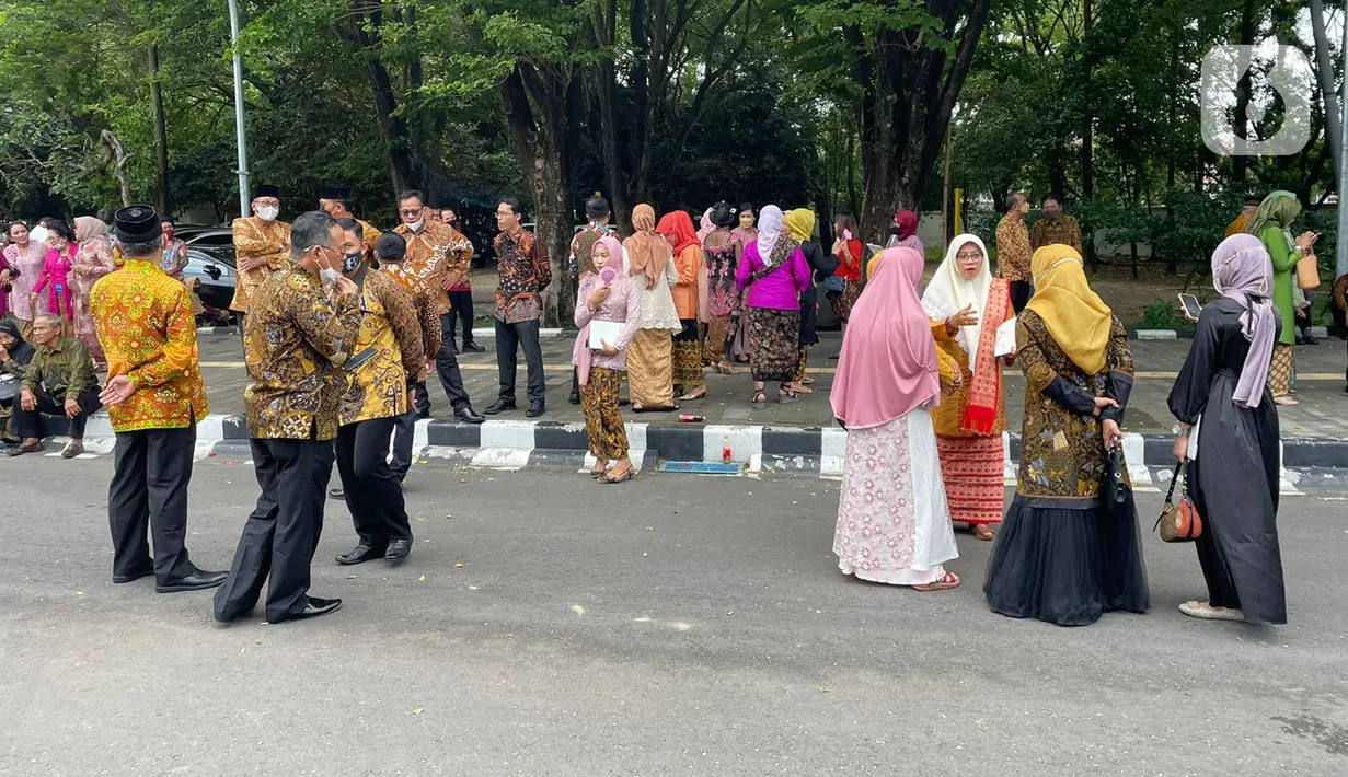 Sejumlah tamu menunggu kedatangan bus yang akan mengangkut mereka menuju resepsi pernikahan putra bungsu Presiden Jokowi, Kaesang Pangarep dan Erina Gudono dari Stadion Manahan, Solo, Jawa Tengah, Minggu (11/12/2022). Setelah turun dari bus, para tamu langsung berjalan kaki menuju tempat pengecekan tamu undangan di sebelah barat pintu masuk Pura Mangkunegaran. (Liputan6.com/Herman Zakharia)