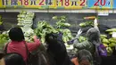 Pelanggan mengenakan masker, membeli sayuran segar di toko pasar basah di Hong Kong, Rabu, 9 Februari 2022. Hong Kong mengumumkan pembatasan virus corona baru yang ketat yang diperparah dengan semakin minimnya pasokan sayuran dikarenakan pengemudi truk yang positif COVID-19. (AP Photo/Vincent Yu)