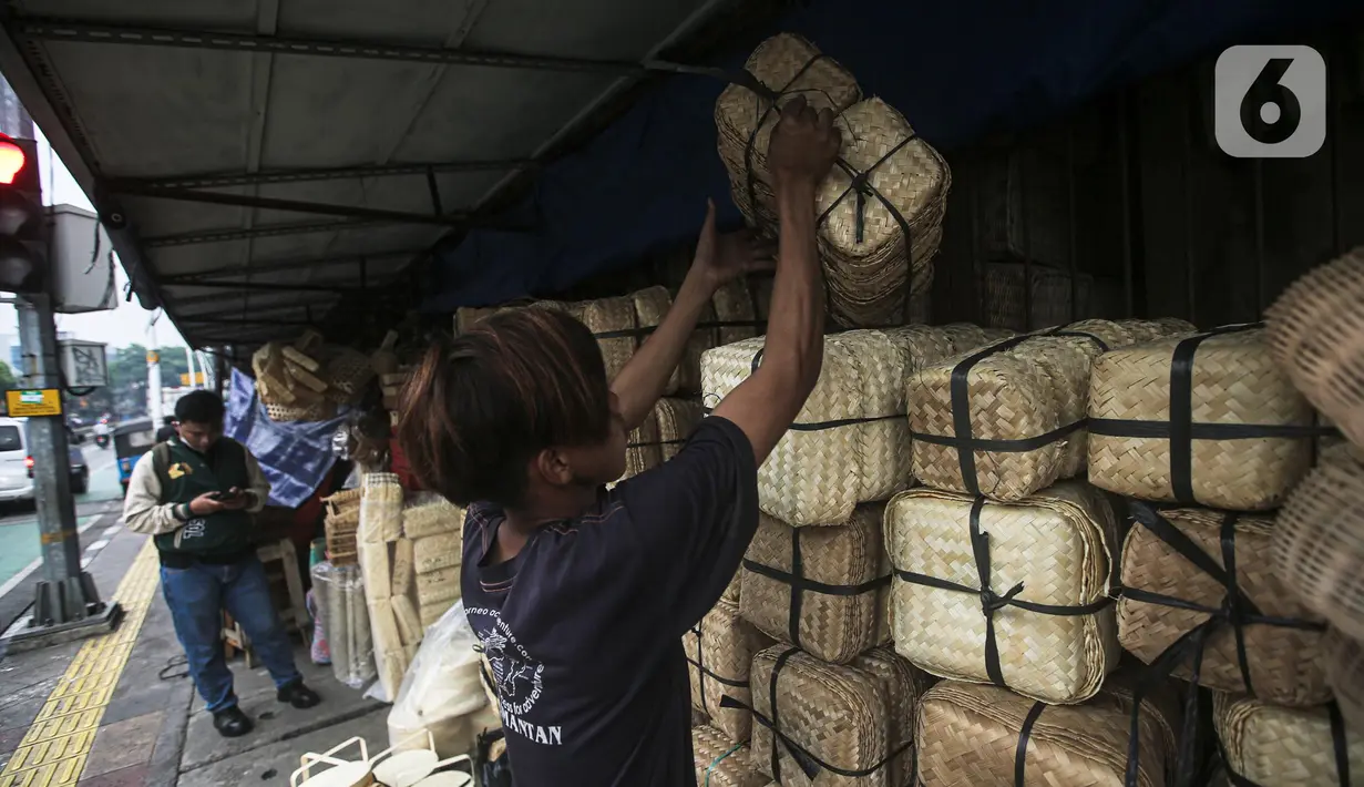 Pedagang menata wadah besek bambu di Kawasan Jatinegara, Jakarta, Rabu (6/7/2022). Jelang Idul Adha, penjualan besek untuk tempat daging kurban yang ramah lingkungan mengalami peningkatan. (Liputan6.com/Faizal Fanani)