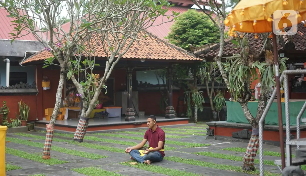 Umat Hindu berdoa di Pura Widya Dharma yang sepi di kawasan Cibubur, Jakarta Timur, Selasa (24/3/2020). Pembatasan aktivitas menjelang Hari Raya Nyepi tahun baru Saka 1942 dilakukan sesuai dengan imbauan pemerintah untuk antisipasi penyebaran virus corona Covid-19. (Liputan6.com/Immanuel Antonius)
