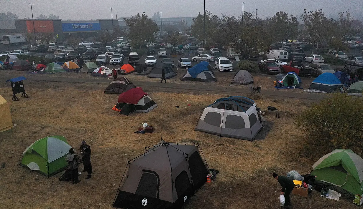 Sejumlah tenda terpasang di kamp pengungsian di sebuah lapangan di samping tempat parkir Walmart, Chico, California, AS (16/11). Akibat kebakaran yang terjadi di California sekitar 63 orang tewas. (AFP Photo/Justin Sullivan)
