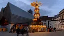 Orang-orang berjalan dekat pasar Natal kecil di shopping street di Ghent, Belgia, Rabu (22/12/2021). Mulai hari Minggu, pihak berwenang telah memutuskan menutup bioskop, teater dan ruang konser, sementara penggemar olahraga akan dilarang masuk stadion dan aula dalam ruangan. (AP Photo/Virginia Mayo)