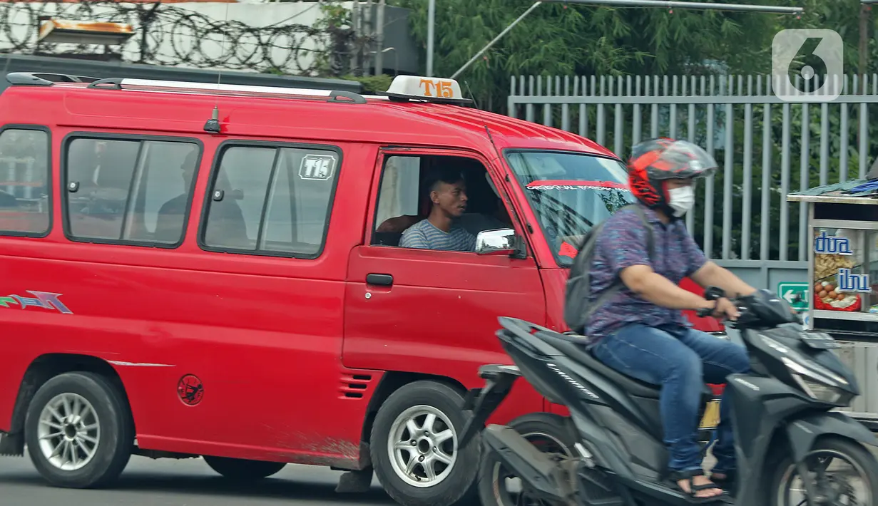 Supir angkot sedang melintas di kawasan Raya Bogor, Jakarta, Jumat (5/2/2021). Di tengah lonjakan kasus COVID-19 masih banyak masyarakat yang abai terhadap protokol kesehatan. (Liputan6.com/Herman Zakharia)
