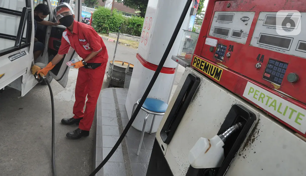 Petugas dengan sarung tangan, masker dan pelindung wajah melayani pembeli BBM di SPBU kawasan Cilendek, Bogor, Selasa (5/5/2020). Mencegah penularan Covid-19, sejumlah perusahaan memberikan pelindung diri kepada pegawai, terlebih yang berhubungan langsung dengan pelanggan. (merdeka.com/Arie Basuki)
