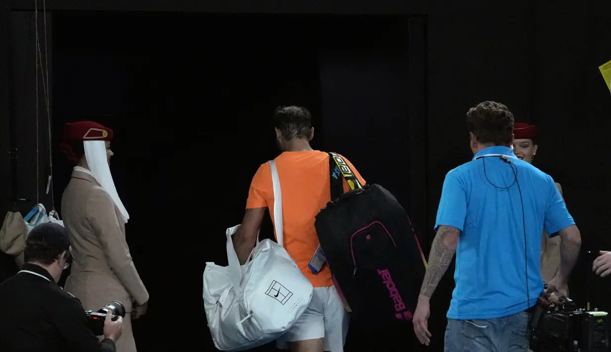 Petenis Spanyol, Rafael Nadal, meninggalkan lapangan usai ditaklukkan petenis Amerika Serikat, Mackenzie McDonald, pada Australian Open 2023 di Melbourne Park, Rabu (18/1/2023). Nadal kalah 6-4, 6-4, 7-5 dari Mackenzie. (AP Photo/Dita Alangkara)