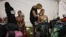 Para seniman melukis di tubuh model perempuan selama Daegu International Bodypainting Festival 2017 di Daegu, Korea Selatan, (26/8). Berbagai seniman ternama dari 10 negara turut hadir di Daegu untuk meramaikan festival tersebut. (Ed JONES / AFP)