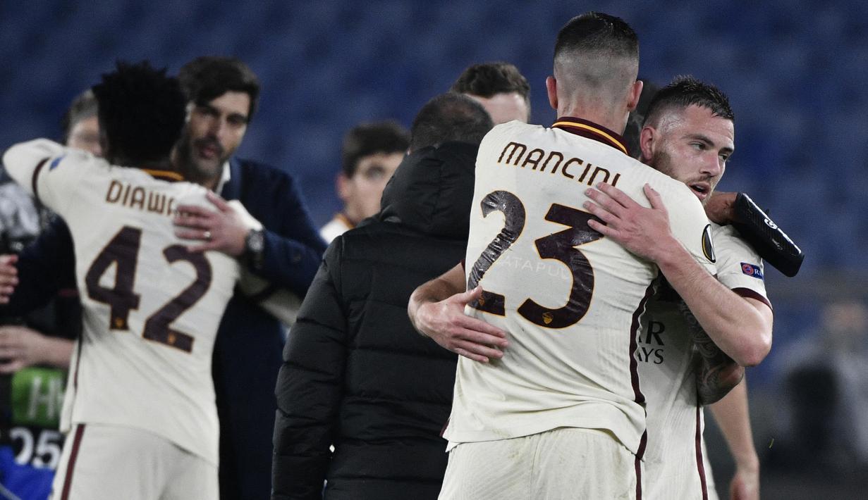Gelandang AS Roma, Jordan Veretout (kanan) bersama Gianluca Mancini merayakan hasil imbang 1-1 melawan Ajax Amsterdam usai berakhirnya laga leg kedua perempatfinal Liga Europa 2020/2021 di Olimpico Stadium, Roma, Kamis (15/4/2021). AS Roma lolos ke semifinal. (AFP/Filippo Monteforte)