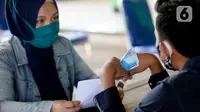 Petugas sedang menyerahkan Bantuan Langsung Tunai Dana Desa (BLT-DD) kepada warga Desa Curug di Kantor Desa Curug, Gunung Sindur, Kabupaten Bogor, Jawa Barat, Kamis (17/09/2020). Bantuan tersebut diberikan kepada 155 per KK untuk bisa mengurangi akibat terdampak COVID-19. (merdeka.com/Dwi Narwoko)