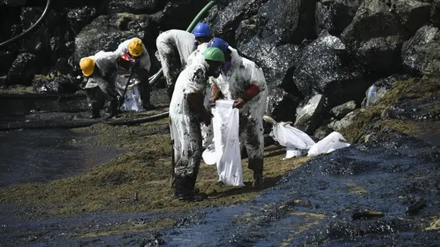 Para pekerja membersihkan tumpahan minyak di Pantai Rockly Bay di Scarborough, Trinidad dan Tobago, pada 10 Februari 2024.
