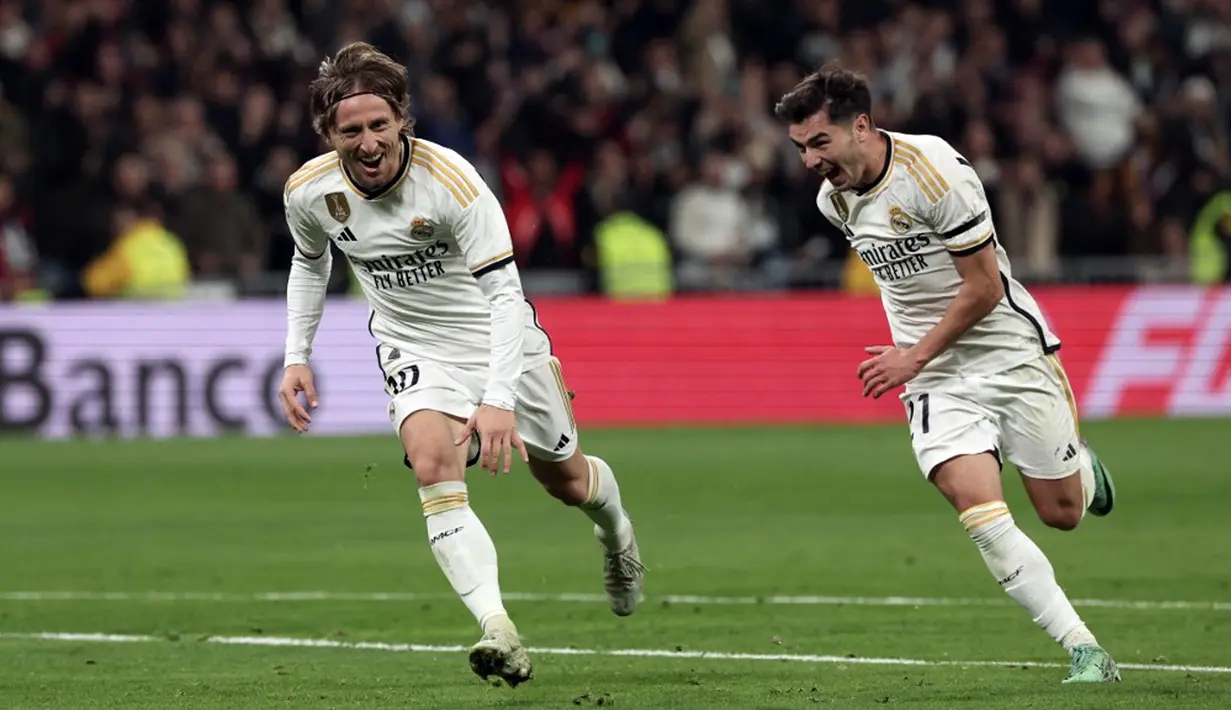 Pemain Real Madrid Luka Modric (kiri) dan Brahim Diaz merayakan gol ke gawang Villarreal pada pertandingan sepak bola Liga Spanyol di Stadion Santiago Bernabeu, Madrid, Spanyol, Minggu (17/12/2023). (Thomas COEX/AFP)