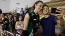 Seorang fans berselfie dengan Tiffany Abreu usai pertandingan liga voli Brasil di Bauru, Brasil,(19/12). Abreu, seorang transgender, mendapat otorisasi untuk bermain di liga voli wanita teratas negara tersebut. (AP Photo / Andre Penner)