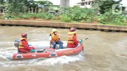 Petugas gabungan mengevakuasi korban dengan perahu karet saat simulasi penanganan banjir di Kalimalang, Cipinang Melayu, Rabu (17/11/2021). Simulasi digelar dalam rangka kesiapsiagaan petugas dalam penanganan korban banjir, terutama evakuasi warga yang terpapar Covid-19 (merdeka.com/Iqbal S Nugroho)
