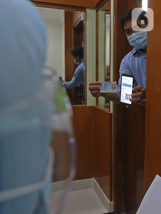 Tenaga kesehatan calon penerima vaksin menunjukkan SMS dan KTP dalam simulasi pemberian vaksin COVID-19 di RSIA Tambak, Jakarta, Rabu (13/10/2021). Rencananya penyuntikan vaksinasi COVID-19 akan dilakukan oleh Pemprov DKI Jakarta pada 15 Januari 2021. (Liputan6.com/Herman Zakharia)