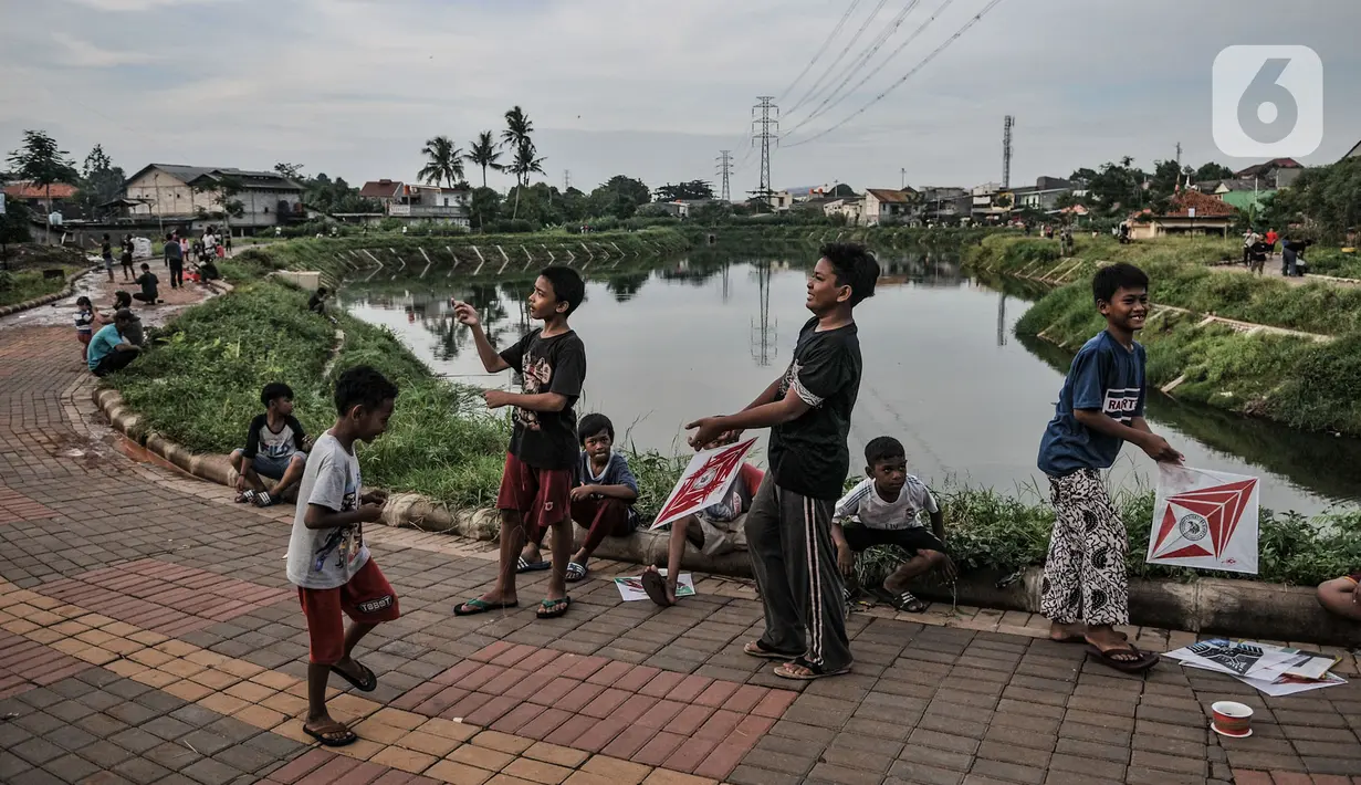 Anak-anak bermain layang di sekitar Waduk Kampung Rambutan 2, Jakarta, Kamis (12/11/2020). Waduk seluas 4,6 hektare yang rampung dibangun oleh Pemprov DKI pada 2019 tersebut kini menjadi lokasi wisata alternatif bagi warga setempat, terlebih saat pandemi Covid-19.  (merdeka.com/Iqbal S. Nugroho)