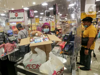 Kasir memasukan barang konsumen yang dibatasi dengan plastik di supermarket AEON Mall BSD City, Tangerang, Rabu (3/6/2020). Pembatasan tersebut dilakukan untuk memberikan jarak sosial dalam interaksi antara kasir dan konsumen selama pandemi Covid-19. (Liputan6.com/Fery Pradolo)