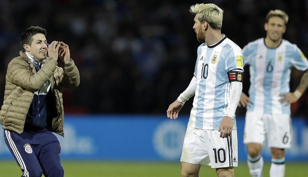 Seorang fans masuk ke lapangan menghampiri bintang Argentina, Lionel Messi, saat laga penyisihan Piala Dunia di Estadio Malvinas Argentinas, Mendoza, Argentina, Jumat (2/9/2016). (AP/Victor R. Caivano)