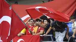 Para suporter Timnas Turki mengibarkan bendera sebelum dimulainya laga persahabatan FIFA Matchday menghadapi Timnas Jepang di Luminus Arena, Genk, Belgia, Selasa (12/9/2023) malam WIB. (AP Photo/Frederic Sierakowski)
