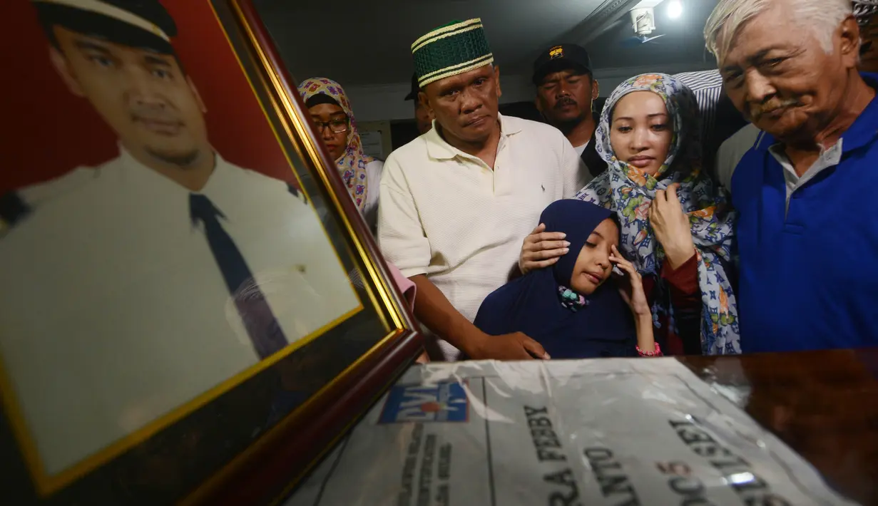 Istri (kedua kanan) dan anak menyambut kedatangan jenazah Yudhistira Febbi Arianto, co pilot pesawat Aviastar di masjid dekat Bandara Ngurah rai, Bali, Kamis (8/10). Pesawat Aviastar jatuh dan menewaskan 3 kru dan 7 penumpang. (AFP PHOTO/SONNY TUMBELAKA)