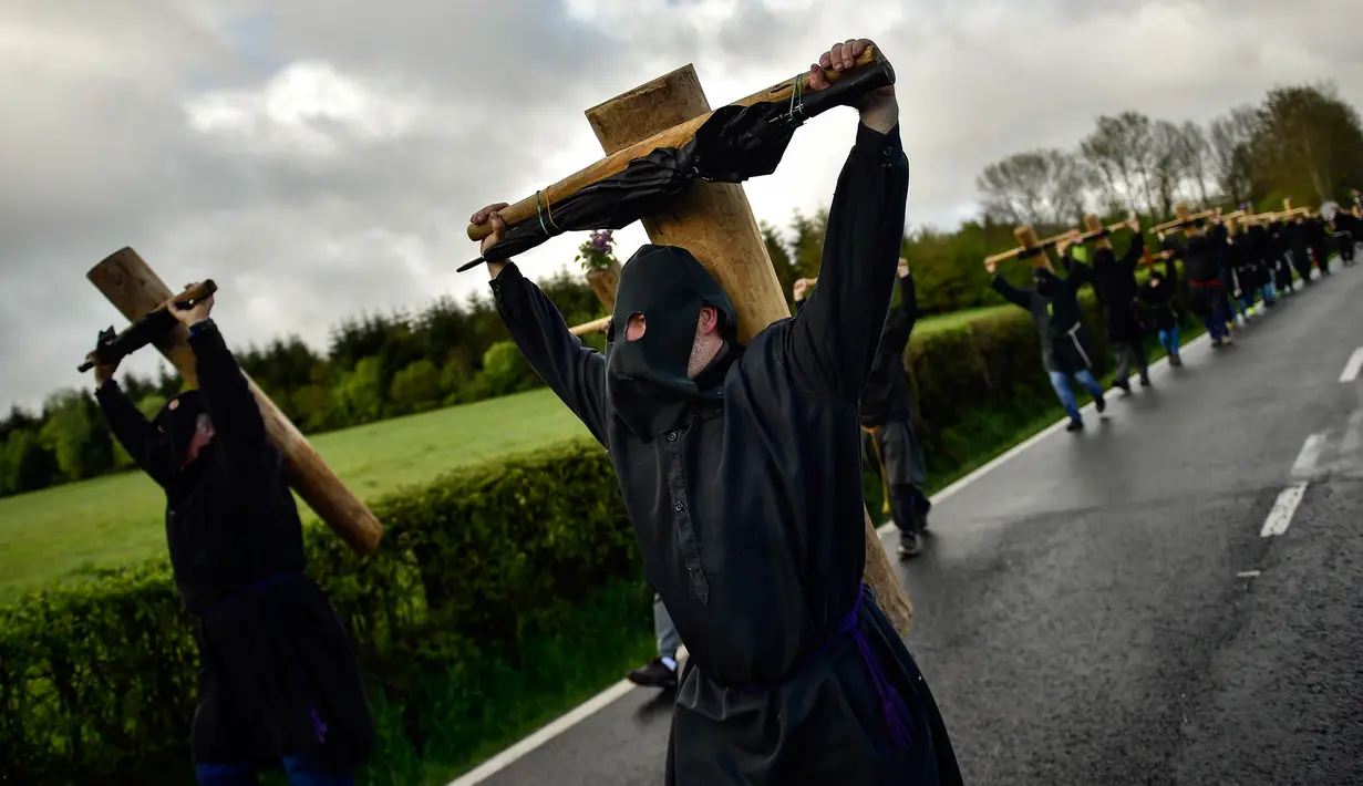 Sejumlah peninten bertopeng membawa salib saat ritual musim semi '' Romeria Cruceros de Arce '' di Spanyol utara (13/5). (AP / Alvaro Barrientos)