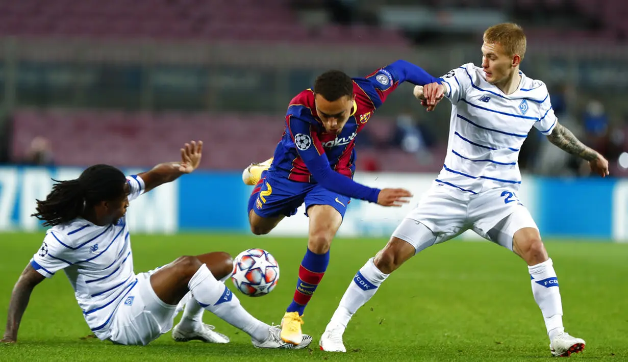 Pemain Barcelona Sergino Dest (tengah) menggiring bola melewati pemain Dynamo Kyiv Gerson Rodrigues (kiri) dan Vitaliy Buyalskyi pada pertandingan Grup G Liga Champions di Camp Nou, Barcelona, Spanyol, Rabu (4/11/2020). Barcelona menang 2-1. (AP Photo/Joan Monfort)