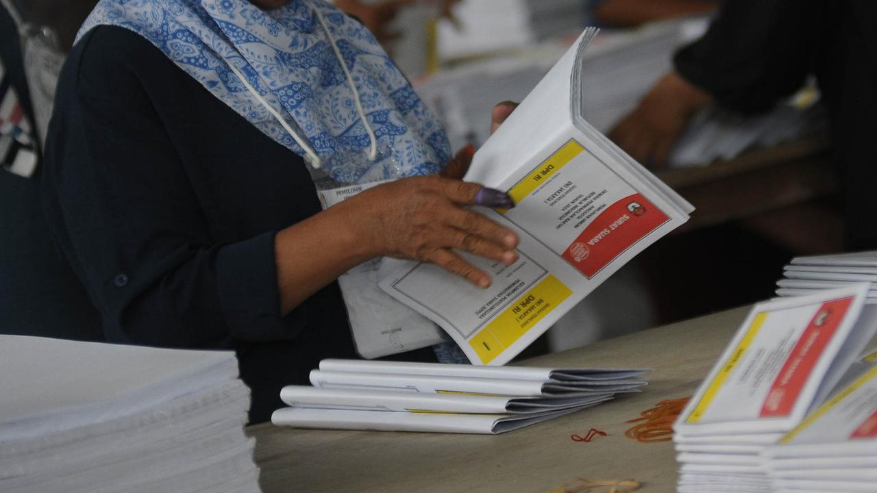 Kesibukan pekerja saat melakukan sortir dan pelipatan surat suara DPR RI DKI Jakarta I di sebuah gudang logistik, Jakarta, Selasa (16/1/2024). <br>