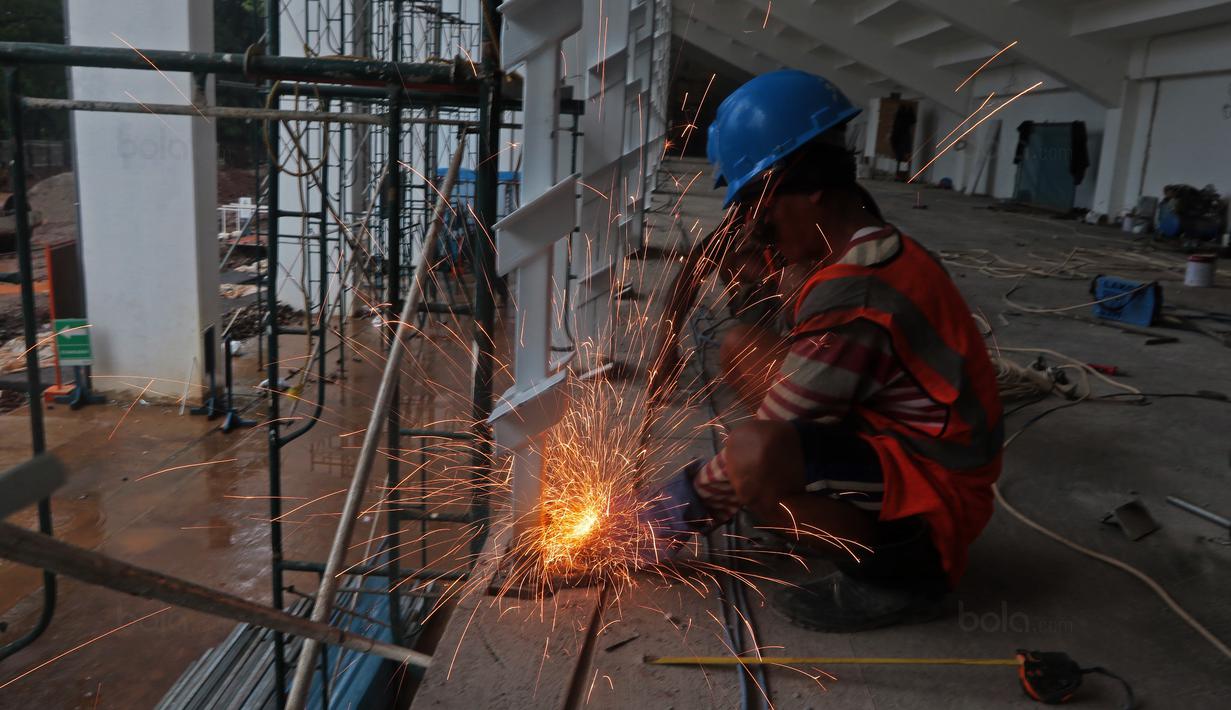 Pekerja saat melakukan perbaikan jendela venue Atletik Stadion Madya di Kawasan Senayan Sport Center, Jakarta (12/10/2017). Renovasi stadion tersebut untuk menyambut Asian Games 2018. (Bola.com/Nicklas Hanoatubun)