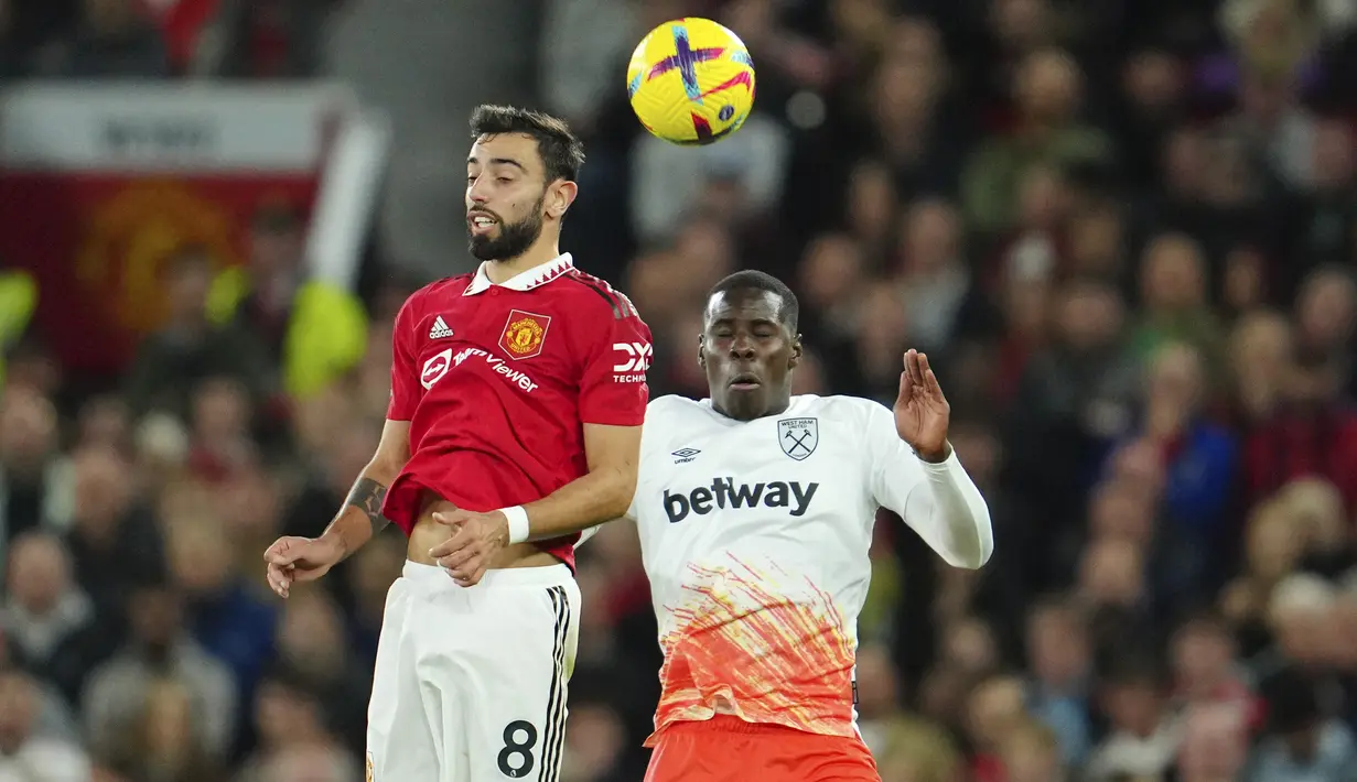 <p>Gelandang Manchester United, Bruno Fernandes berebut bola udara dengan pemain West Ham, Kurt Zouma selama pertandingan lanjutan Liga Inggris di stadion Old Trafford di Manchester, Inggris, Minggu, 30 Oktober 2022. Manchester United menang atas West Ham 1-0. (AP Photo/Jon Super)</p>