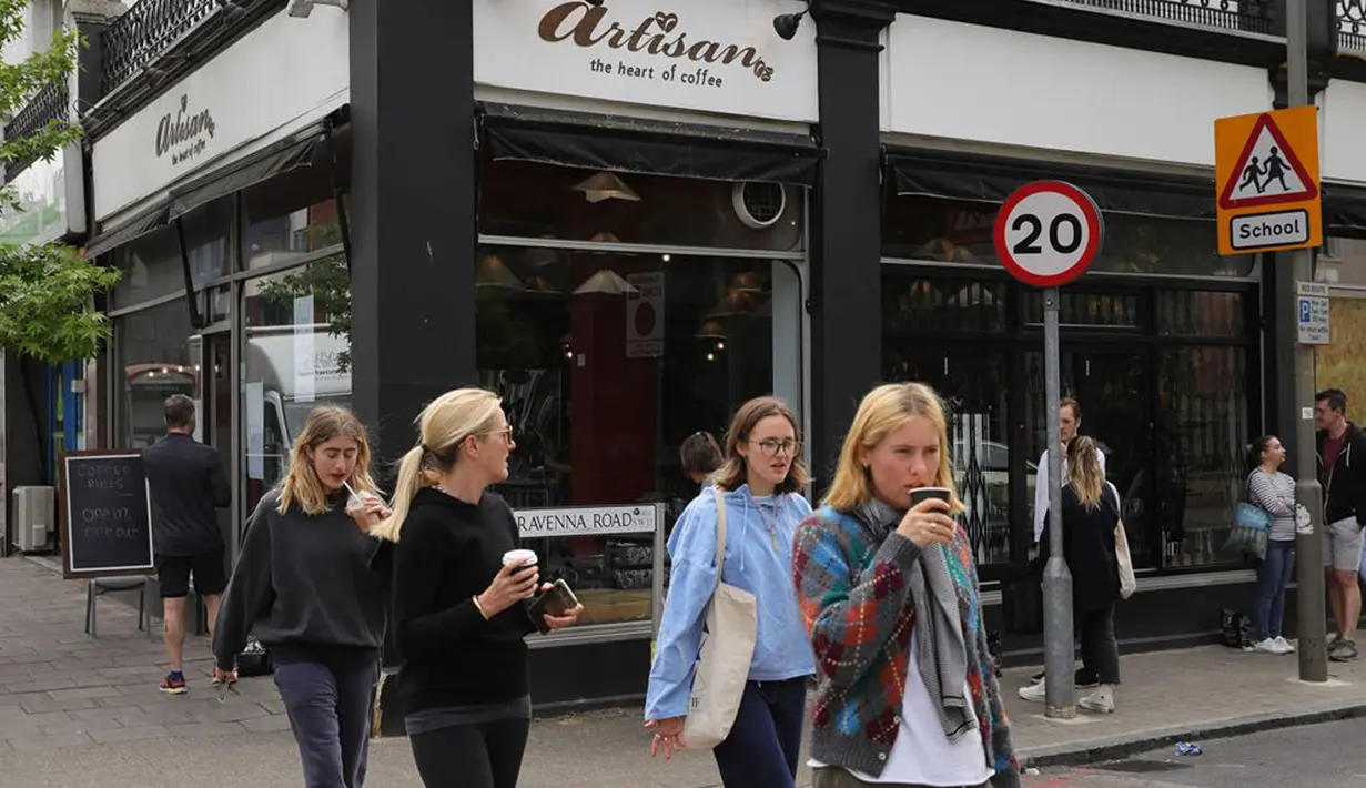 Warga berjalan melewati sebua kedai kopi di London, Inggris, Minggu (17/5/2020). Beberapa restoran, kafe, dan toko katering di Inggris secara bertahap kembali buka setelah pemerintah melonggarkan kebijakan lockdown akibat virus corona COVID-19. (Xinhua/Tim Ireland)