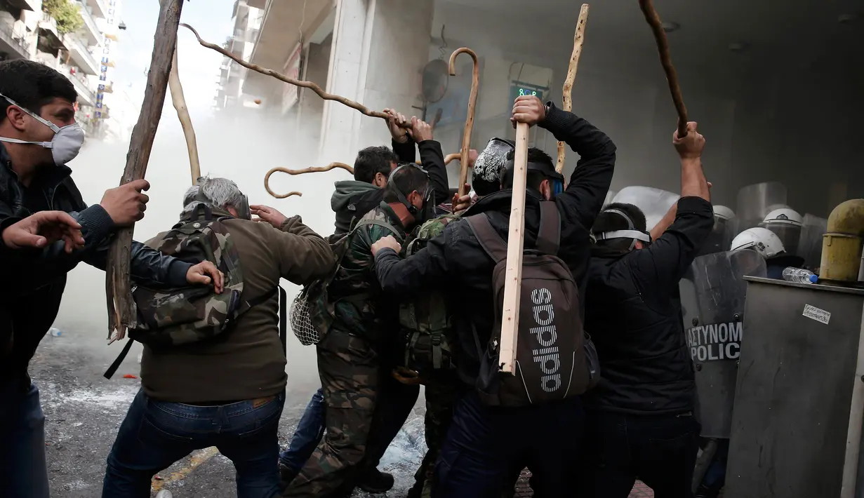 Sejumlah petani Yunani dari wilayah Crete saat bentrok dengan polisi selama protes petani terhadap perubahan peraturan pensiun yang direncanakan di luar Kementerian Pertanian, Athena, Yunani, Jumat (12/2). (REUTERS/Alkis Konstantinidis)	