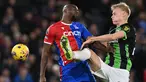 Striker Crystal Palace #14 Jean-Philippe Mateta (kiri) dan bek Brighton and Hove Albion #29 Jan Paul van Hecke berebut bola di udara pada laga pekan ke-18 Premier League di Selhurst Park, Jumat (22/12/2023) dini hari WIB. (Glyn KIRK / AFP)