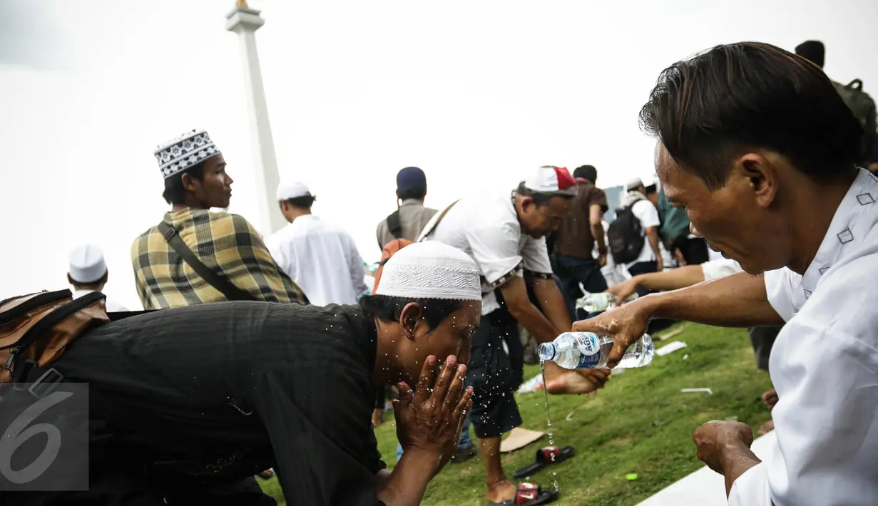 Peserta aksi damai 212 mengambil air wudhu dengan botol air minum untuk berwudhu di Monas, Jakarta, Jumat (2/12). Demo 2 Desember digelar sebagai lanjutan dari aksi 4 November 2016. (Liputan6.com/Faizal Fanani)