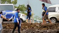 Suporter Persib melintasi tanah becek untuk menyaksikan laga Persib vs Mitra Kukar di Piala  Bhayangkara di Stadion Si Jalak Harupat, Bandung, Kamis (17/3/2016). Laga Persib kontra Mitra Kukar   berakhir imbang 1-1. (Liputan6.com/Helmi Fithriansyah)