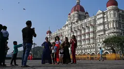 Turis berkunjung di dekat hotel Taj Mahal Palace, salah satu lokasi serangan teroris 2008, di Mumbai (26/11/2021). (AFP/Punit Paranjpe)