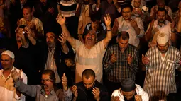 Muslim Palestina memanjatkan doa sambil menunggu Lailatul Qadar di luar Dome of the Rock, kompleks masjid Al-Aqsa di Kota Tua Yerusalem, Senin (11/6).Malam Lailatul Qadar juga disebut malam yang lebih baik daripada malam seribu bulan. (AFP/AHMAD GHARABLI)