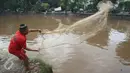 Warga memancing ikan di bantaran Sungai Ciliwung, Jakarta, Selasa (21/2). Meluapnya Sungai Ciliwung menjadi berkah tersendiri bagi warga untuk memancing dan menjala ikan yang terbawa arus dari hulu. (Liputan6.com/Immanuel Antonius)