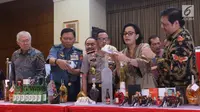 Menteri Keuangan Sri mulyani (kedua kiri) menunjukkan barang bukti hasil sitaan di Bea dan Cukai, Jakarta, Kamis (15/2). Sebanyak 142.519 botol minuman keras dan  12.919.499 batang rokok dimusnakan. (Liputan6.com/Anggan Yuniar)