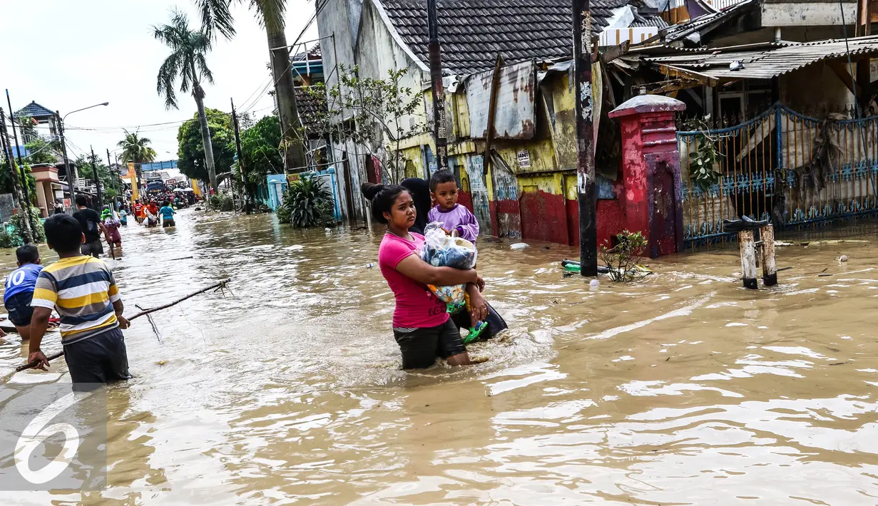 Warga melintas di kawasan banjir di Perumahan PGP Jatiasih, Bekasi, Jawa Barat, Jumat (22/4). Ketinggian air mencapai 1,5 meter dari sebelumnya ketinggian mencapai hampir 4 meter. (Liputan6.com/Fery Pradolo)