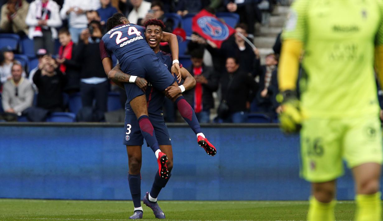 Aksi pemain PSG, Presnel Kimpembe mengnangkat rekannya Christopher Nkunku usai membobol gawang FC Metz pada lanjutan Ligue 1 Prancis di Parc des Princes Stadium, Paris (10/3/2018). PSG menang telak 5-0. (AP/Thibault Camus)