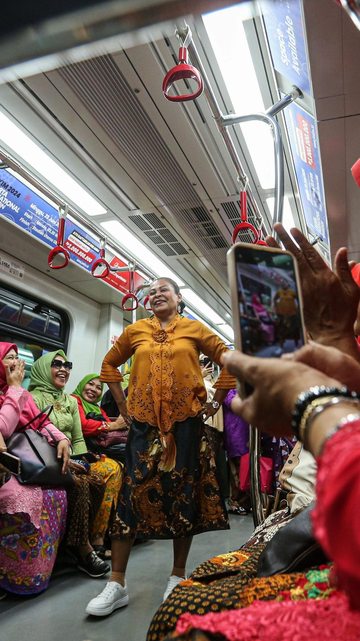 Seseorang sedang mengambil gambar peserta saat bergaya di dalam gerbong LRT.&nbsp;(Liputan6.com/Angga Yuniar)