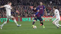 Penyerang Barcelona Lionel Messi (tengah) menggiring bola melewati pemain Real Madrid Toni Kroos dan Luka Modric saat bertanding pada leg pertama semifinal Copa del Rey di Stadion Camp Nou, Barcelona, Spanyol, Rabu (6/2). (AP Photo/Emilio Morenatti)