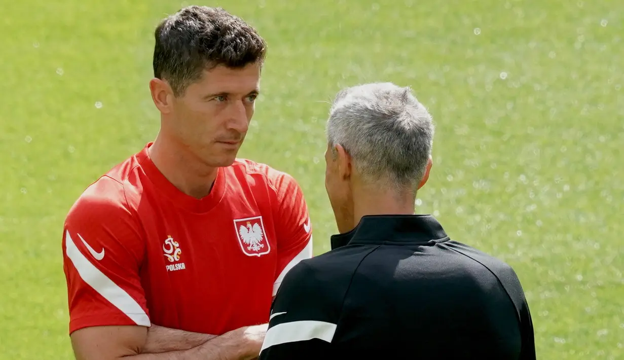 Pemain depan timnas Polandia, Robert Lewandowski (kiri) mendengarkan pelatih Paulo Sousa saat sesi Latihan di Arena Gdansk di Gdansk, Minggu (13/6/2021). Pertandingan pembuka Grup E Euro 2020 akan mempertemukan Polandia vs Slovakia di Stadion Krestovsky pada Senin (14/6) WIB. (JANEK SKARZYNSKI/AFP)