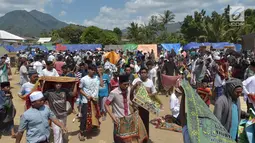 Umat muslim usai melaksanakan salat Jumat di sebuah ladang di dekat tempat penampungan sementara setelah gempa di Pemenang, Lombok (10/8). Jumlah Korban tewas akibat gempa dahsyat 6,9 SR di pulau Lombok melonjak di atas 300 orang. (AFP Photo/Adek Berry)