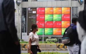 Pejalan kaki melintas dekat layar pergerakan Indeks Harga Saham Gabungan (IHSG) di kawasan Jakarta, Senin (13/1/2020). IHSG sore ini ditutup di zona hijau pada level 6.296 naik 21,62 poin atau 0,34 persen. (Liputan6.com/Angga Yuniar)