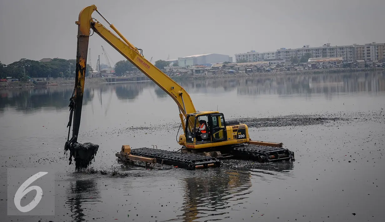 Alat berat dikerahkan untuk mengeruk sampah dari dasar Waduk Pluit, Jakarta, Senin (3/10). Sampah tersebut berasal dari bekas permukiman warga yang pernah mendiami wilayah tersebut. (Liputan6.com/Faizal Fanani)