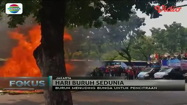 Karangan bunga yang berhari-hari tidak dibersihkan di depan Balai Kota DKI Jakarta dibakar buruh.
