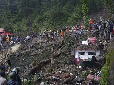 Tim penyelamat membersihkan lumpur dan puing-puing saat mereka mencari orang-orang yang dikhawatirkan terjebak setelah tanah longsor di dekat sebuah kuil di pinggiran Shimla, negara bagian Himachal Pradesh, Senin, 14 Agustus 2023. (AP Photo/Pradeep Kumar)