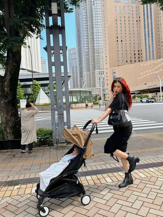 Tetap slay sambil dorong stroller, Tasya tampil kece serba monokrom, memadukan t-shirt, obi belt, dan pencil skirt.  [Foto: IG/tasyafarasya].